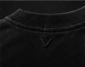 Macro detail of the back-neck V embroidery